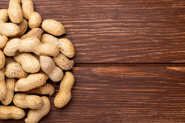 Top view copy space peanuts in shell on a wooden table