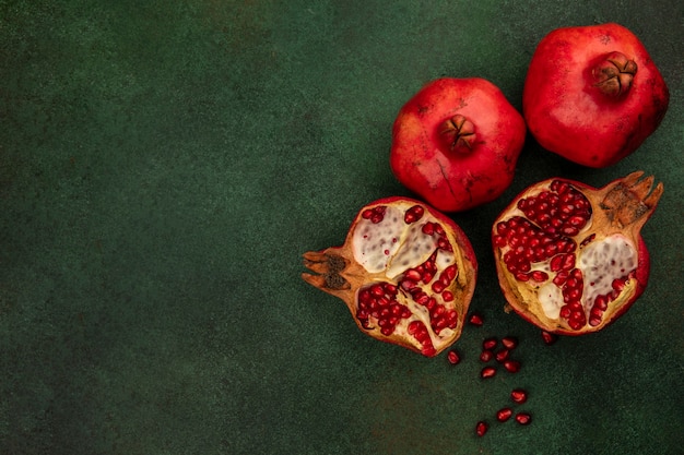 Free photo top view copy space pomegranate halves on green wall