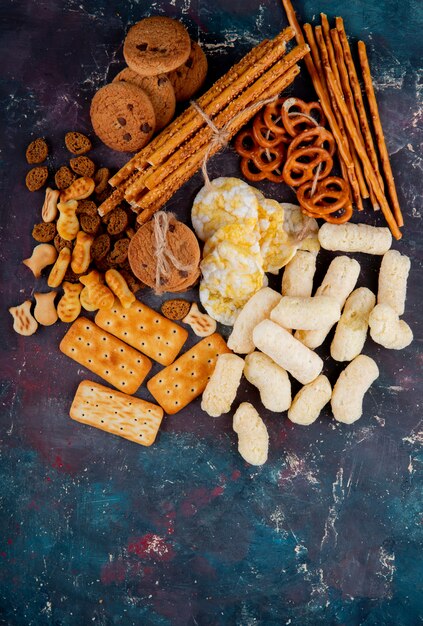 Top view copy space salted cookies with breadcrumbs and breadsticks on a pink and blue background