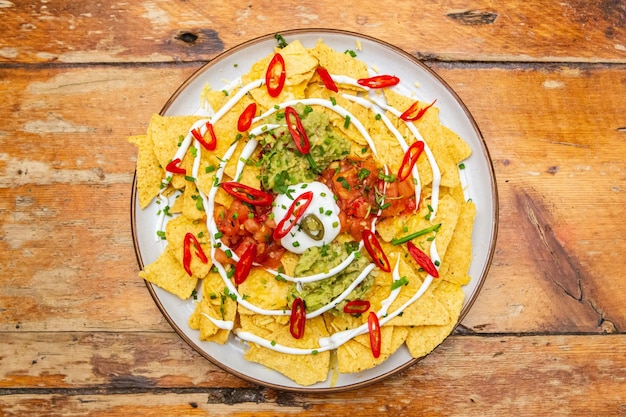 Top view of corn chips with guacamole and chili