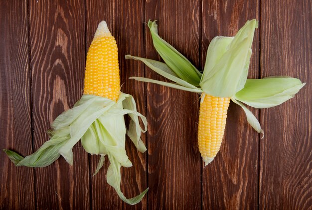 Top view of corn cobs with shell on wood