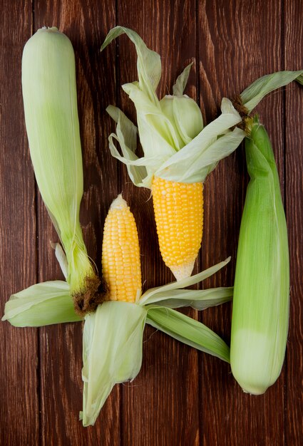 Top view of corn cobs with shell on wood