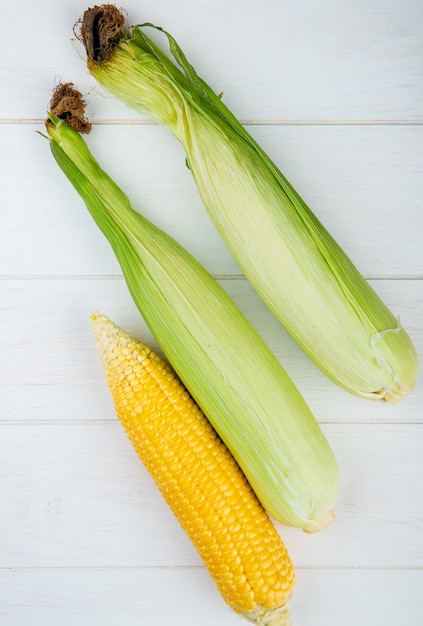 Free photo top view of corn cobs on wooden surface