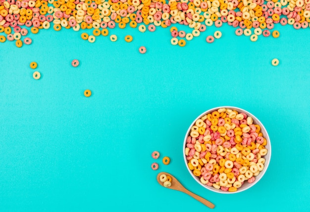 Top view of corn rings in bowl on blue background horizontal