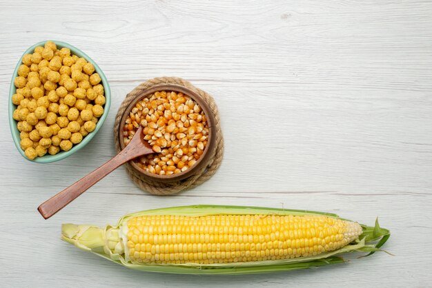 Top view corn seeds yellow colored with cereals inside plate on white