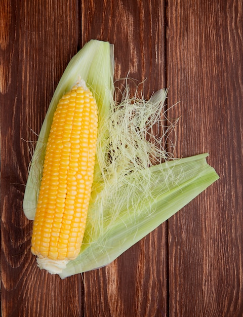 Top view of corn with shell on wood