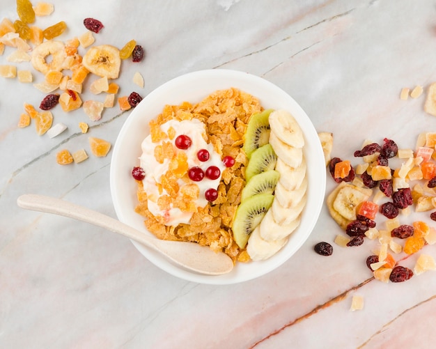 Top view cornflakes bowl with yogurt and fruits