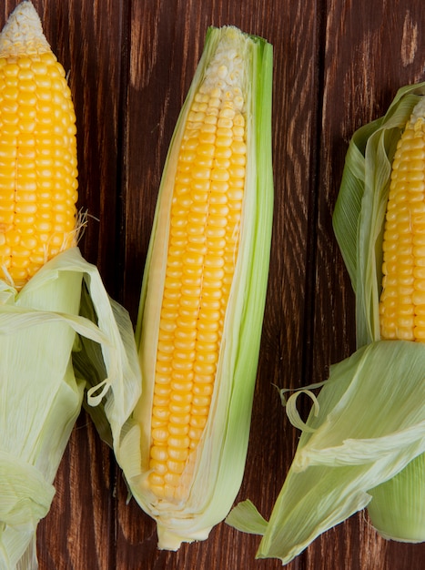 Top view of corns with shell on wooden surface 2