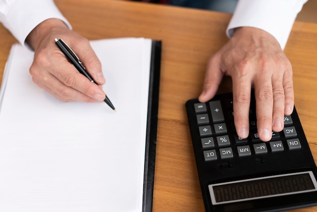 Top view corporate man using calculator