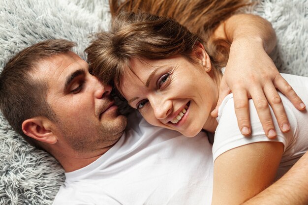 Top view couple embracing and sitting in bed