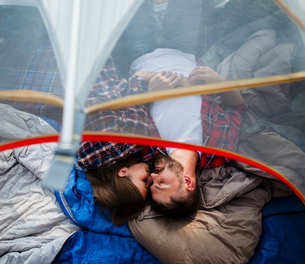 Top view couple hugging in tent