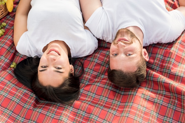 Top view couple laying on picnic blanket