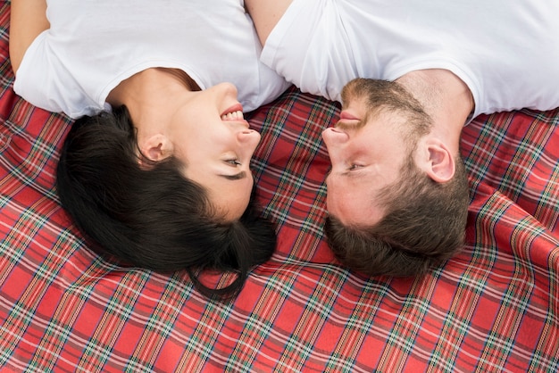 Free photo top view couple laying on picnic blanket