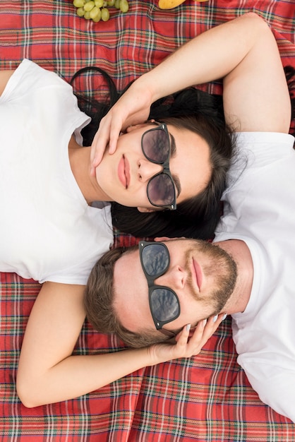 Top view couple laying on picnic blanket