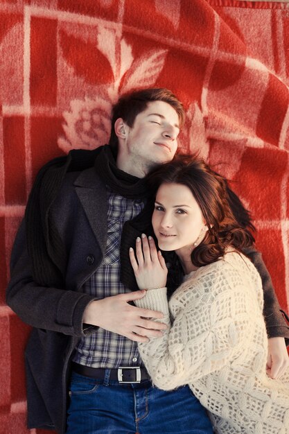 Top view of couple lying on a red blanket