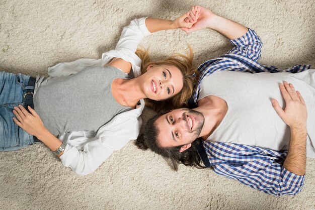 Top view couple portrait laying on carpet