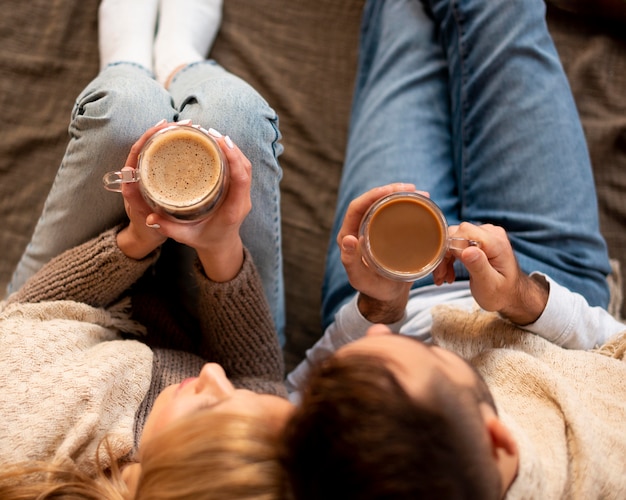 Top view couple with hot drinks