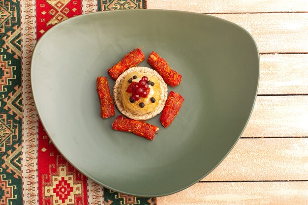 Top view of cracker and cake inside green plate with nougat