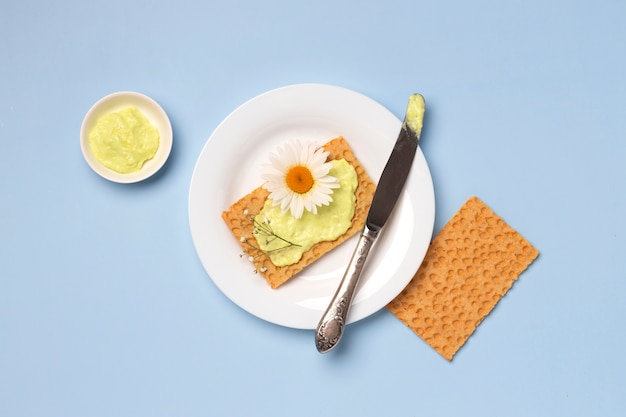 Free photo top view cracker with flower on plate