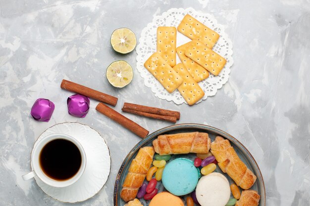 Top view crackers and bagels with cup of tea on white