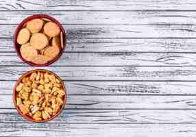 Free photo top view of crackers in bowls with copy space on right on white wooden  horizontal