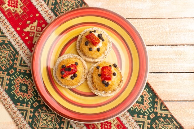 Top view of crackers and cakes inside colored plate