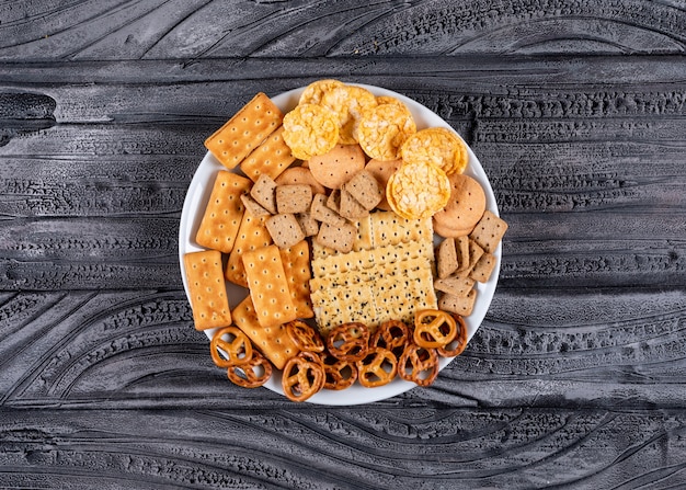 Top view crackers on white plate on gray stone  horizontal