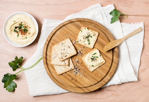 Top view of crackers with bowl of hummus