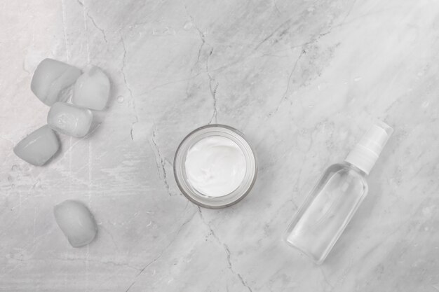 Top view of cream and bottle on marble background