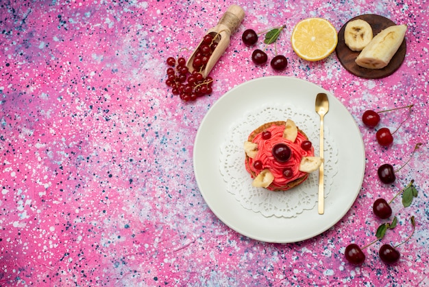 Torta alla crema vista dall'alto con frutta fresca sullo sfondo viola torta biscotto zucchero torta colore