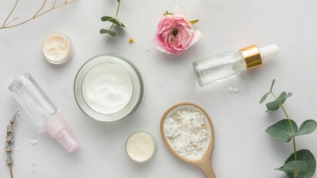 Top view cream container, serum and plants