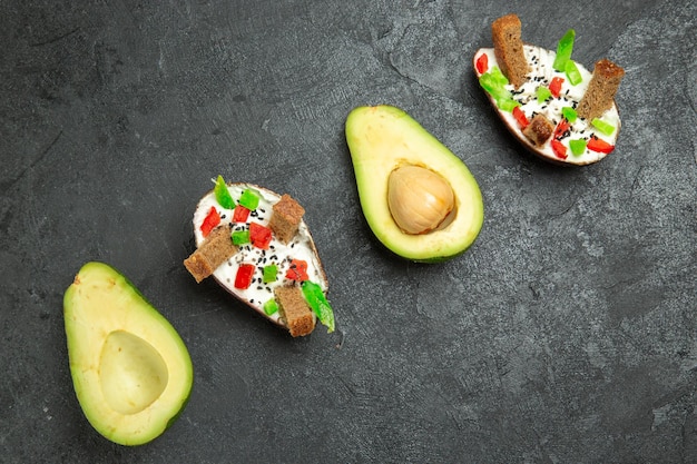 Top view of creamy avocados with fresh avocados on the grey surface