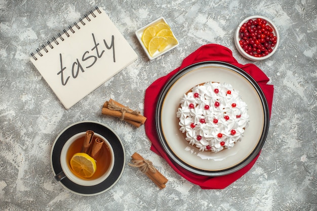 Top view of creamy cake decorated with fruits on a red cloth