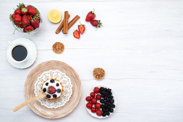 가벼운 책상, 달콤한 케이크에 계피 커피 열매와 함께 딸기와 크림 케이크의 상위 뷰