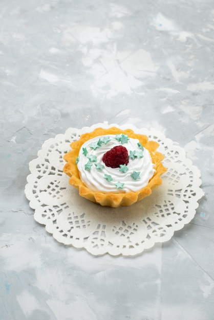 Torta cremosa vista dall'alto con caramelle stella e lampone sulla superficie grigia dolce