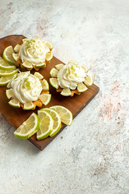 Top view creamy delicious cakes with lemon slices on white surface cake biscuit cookies sweet tea cream