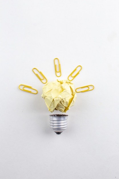 無料写真 白いテーブルの上の紙の宝石クリップによって作られた上面図の創造的なアイデア電球