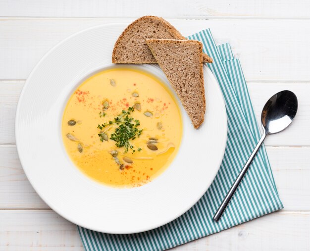 Top view creme soup with slices of bread