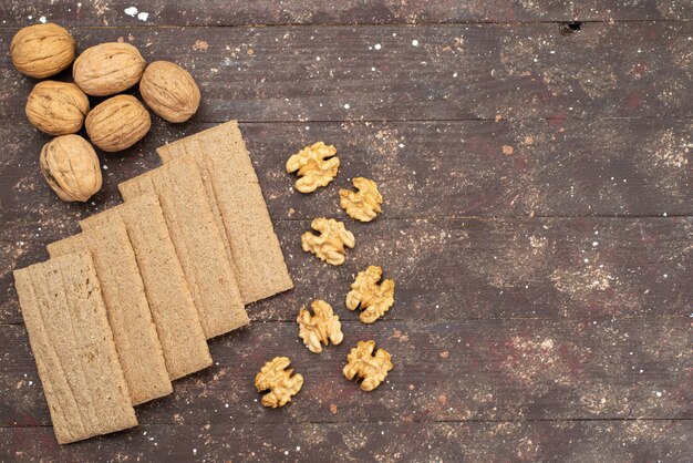 Top view crisps and walnuts isolated on brown