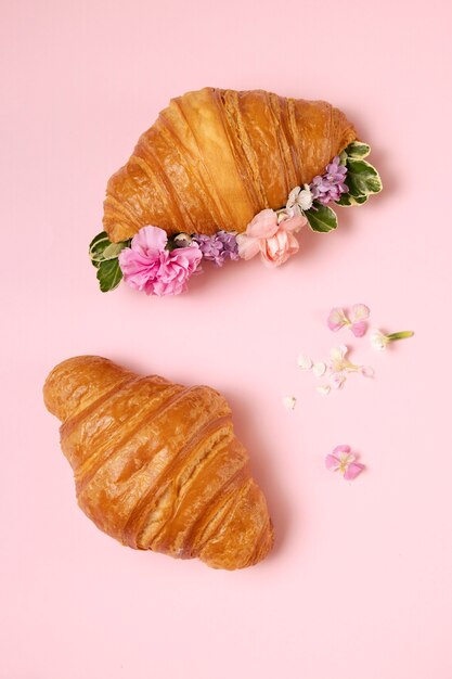 Top view croissants and flowers arrangement