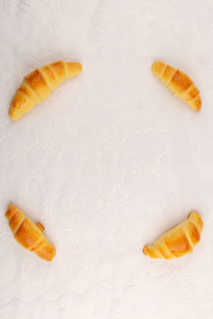 Vista dall'alto croissant squisiti deliziosi sul pavimento bianco