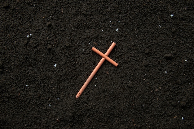 Top view of cross on soil grim reaper devil death