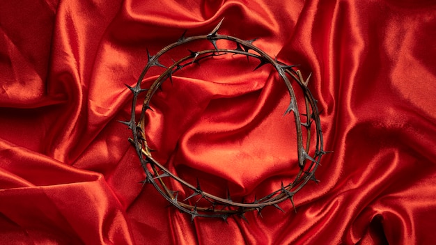 Free photo top view crown of thorns on red cloth