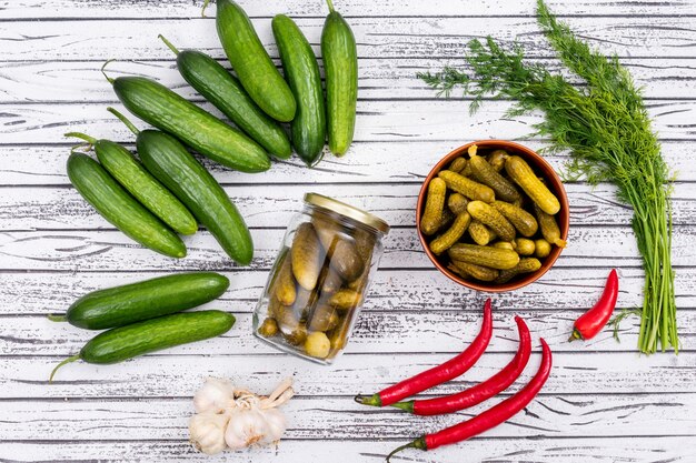 Top view cucumber pickled and fresh with chilli garlic and dill on white wooden