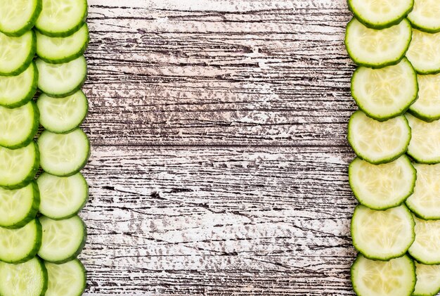 Top view cucumber sliced with copy space i middle on white wooden  horizontal