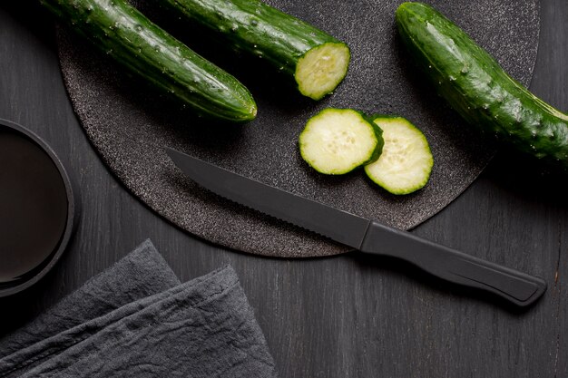 Top view cucumber and slices with knife