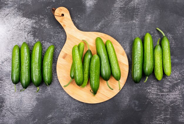 Top view cucumber on wooden cutting board on black stone  horizontal