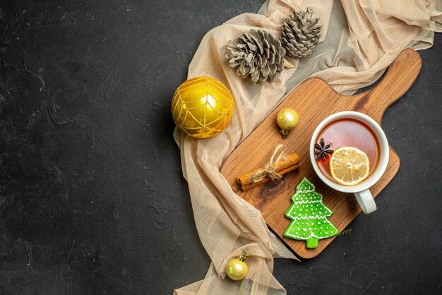 누드 컬러 타월에 나무 커팅 보드에 레몬과 계피 라임 새해 장식 액세서리와 함께 홍차 한잔의 상위 뷰