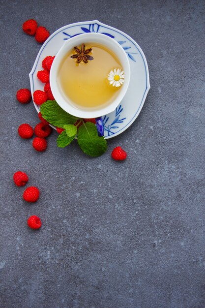 상위 뷰 민트 잎과 접시에 딸기와 카모마일 차 한 잔.