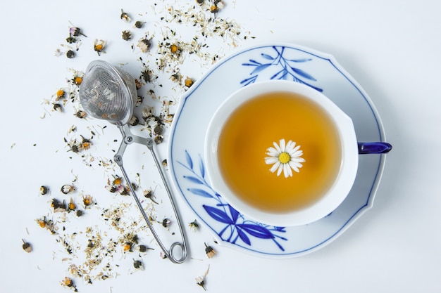 Top view a cup of chamomile with herbs.
